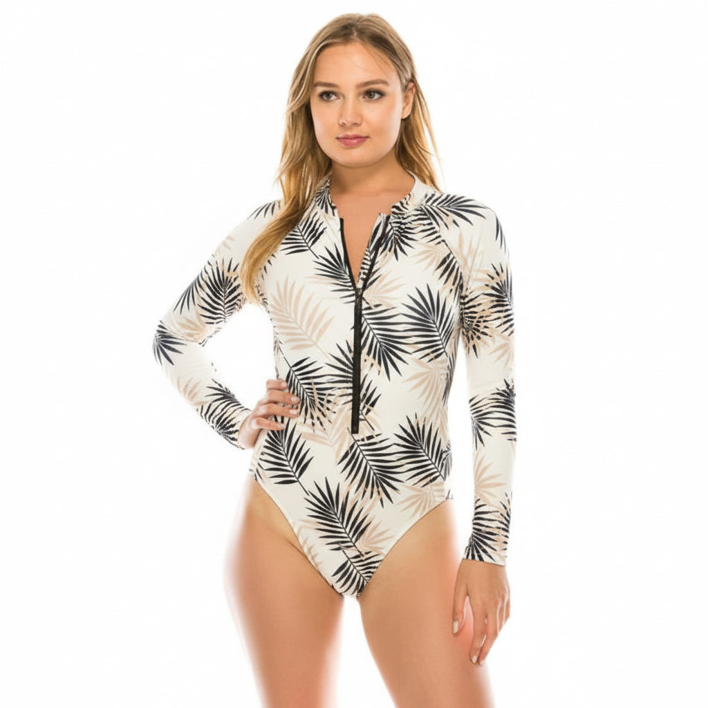 raje de baño entero para mujer con manga larga y cierre frontal, estampado tropical en tonos azul y rosa, modelo en estudio con fondo blanco.